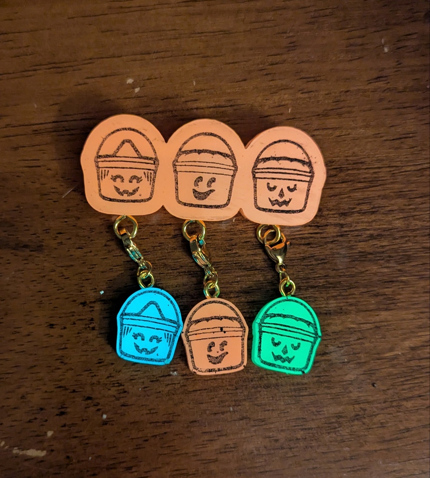 Set of colorful keychains with cartoon-style faces on a wooden surface