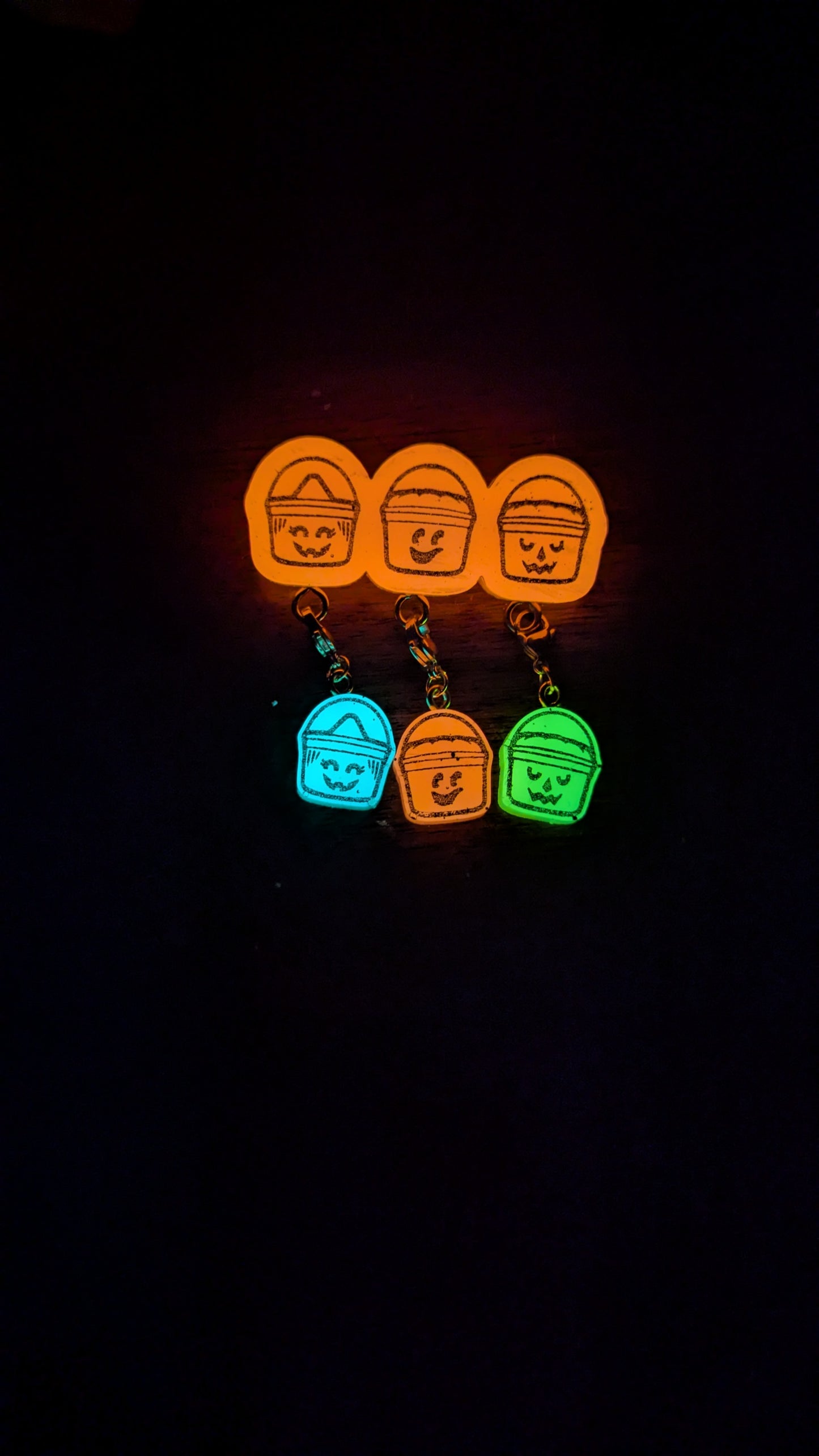 Set of colorful keychains with character designs on a black background