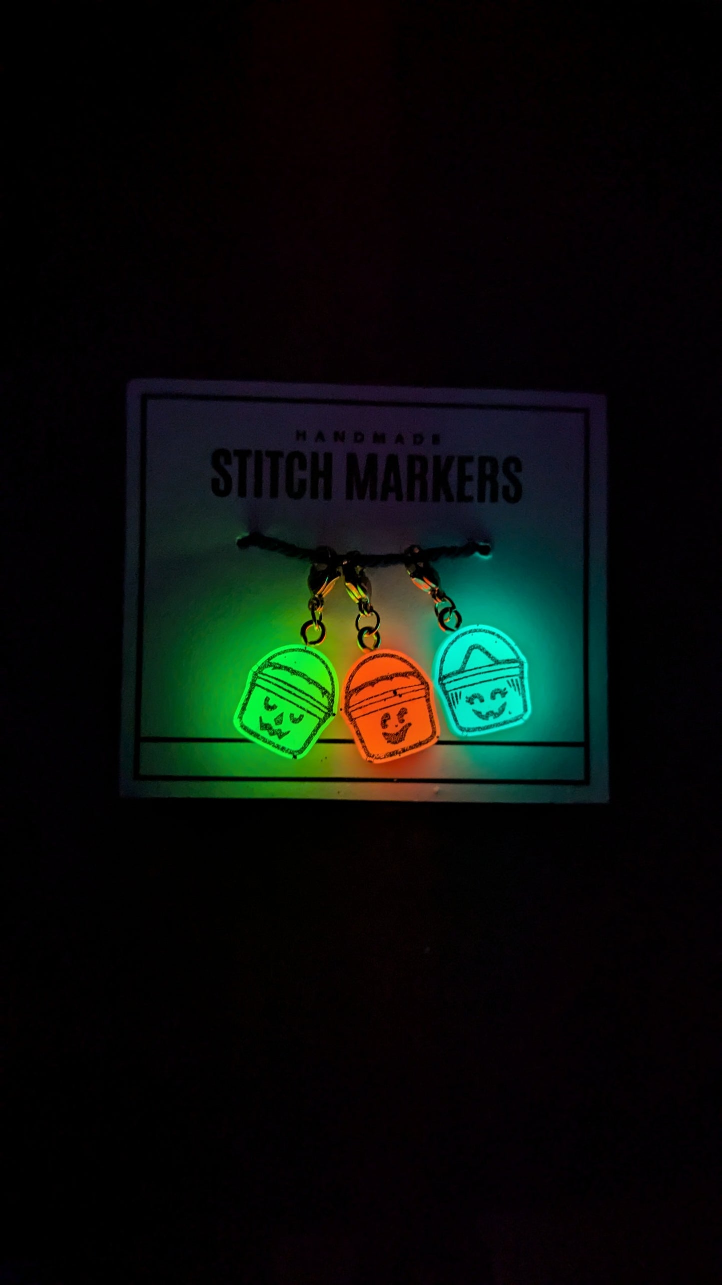 Glowing stitch markers on a dark background