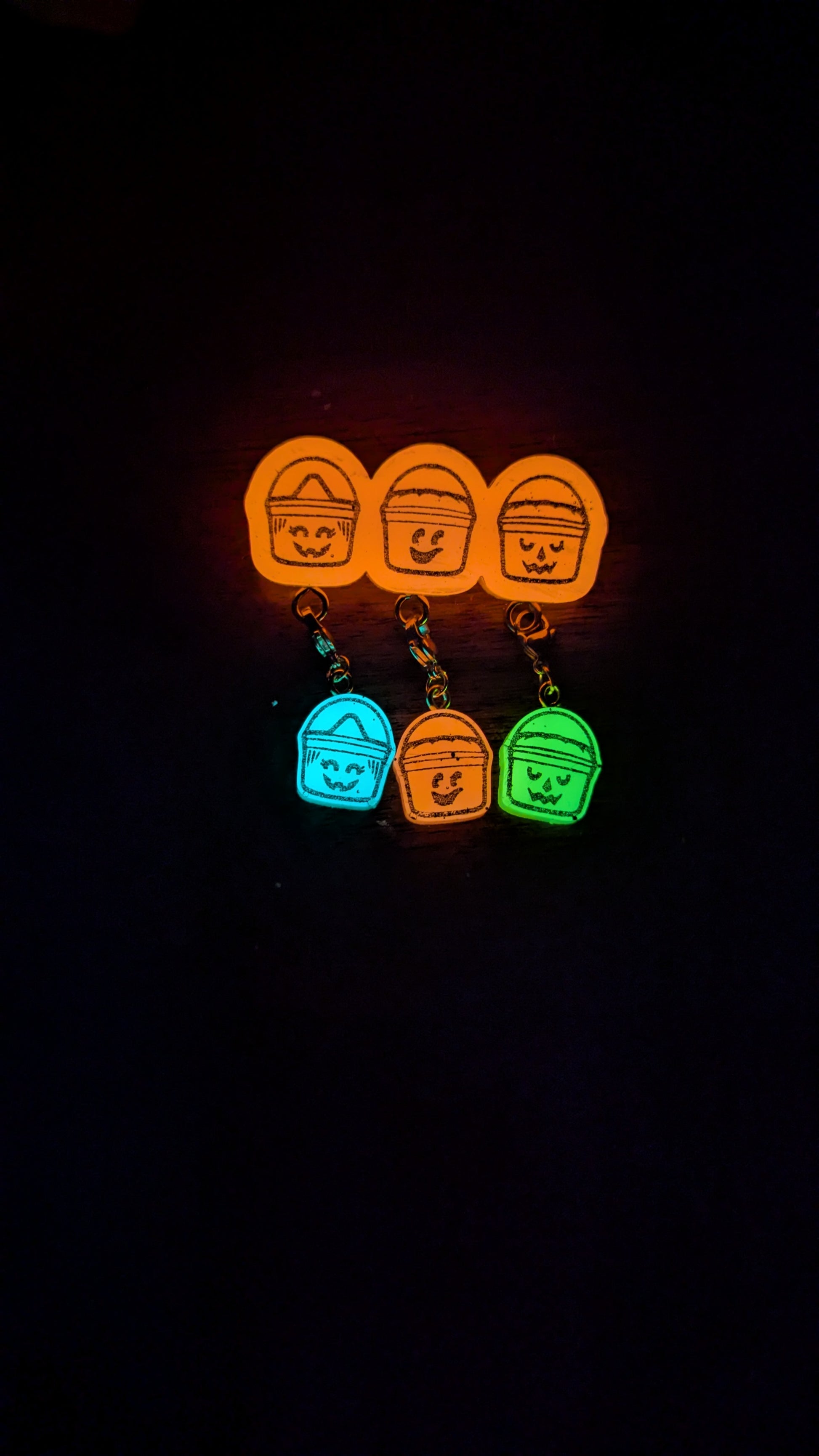 Set of colorful keychains with character designs on a black background